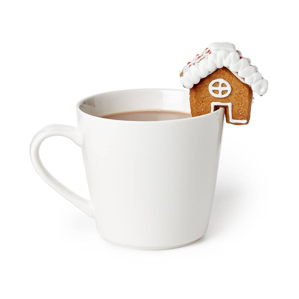 White mug with a gingerbread house-shaped cookie on a white background.