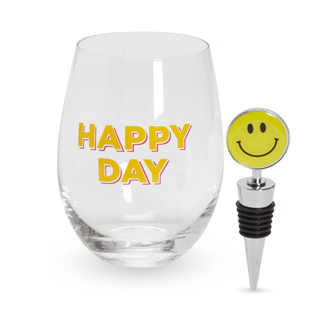 Two's Company clear stemless wine glass with "happy day" in yellow lettering with smiley face bottle stopper.