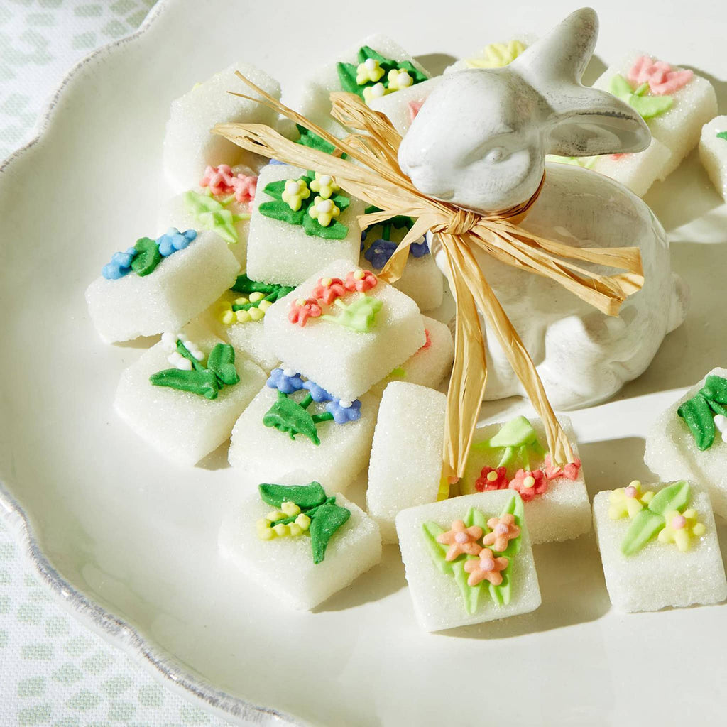 Two's Company Pretty Sweet hand-decorated sugar cubes with floral designs on a white plate with ceramic bunny.