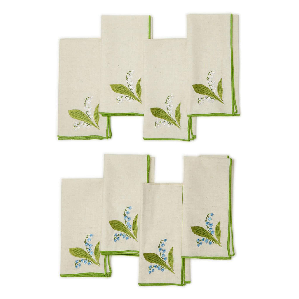 Two's Company Lily of the Valley embroidered cotton chambray napkins with white or blue flowers and green border, folded and shown in sets of 4.