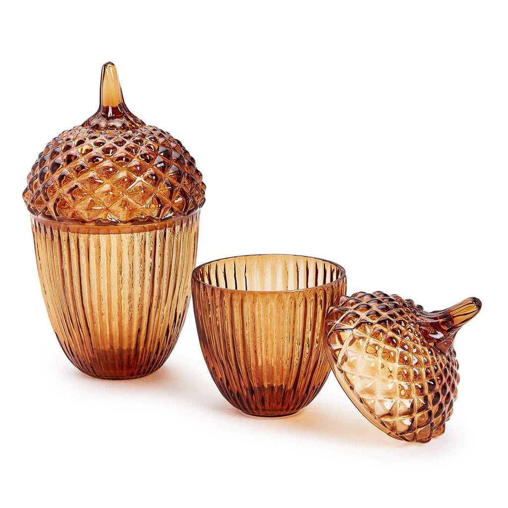 Two's Company Large and Small Amber Glass Acorn Jars with Lids, lid is  off the small jar.