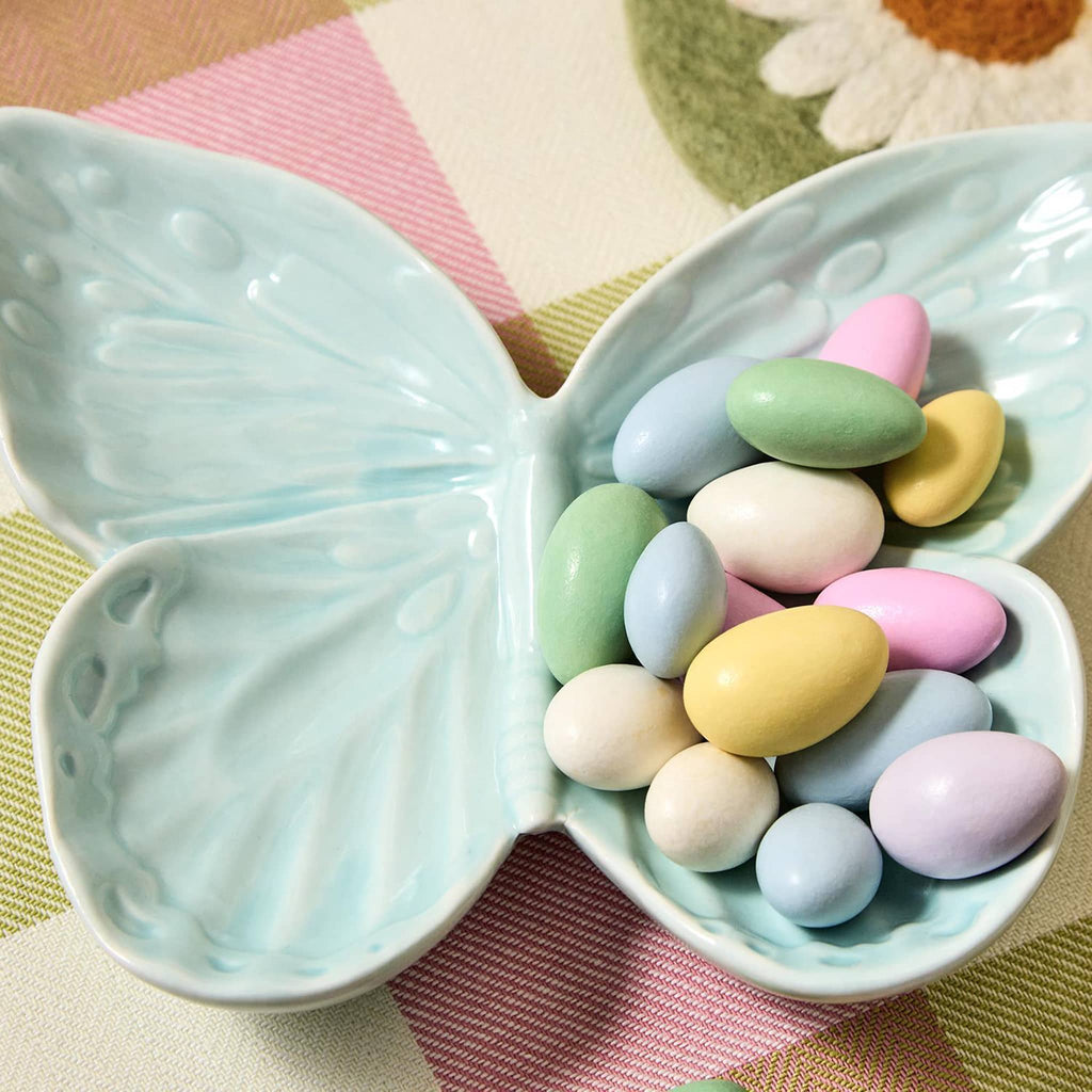 Two's Company Butterfly-shaped porcelain tidbit dish in blue with candy coated almonds.