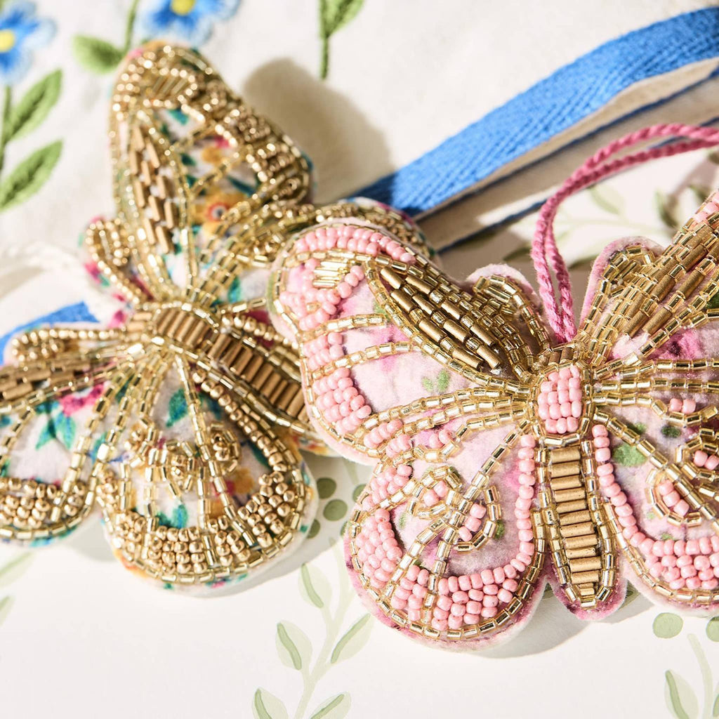 Two's Company Hand-Beaded Butterfly Ornaments in gold and pink, detail.