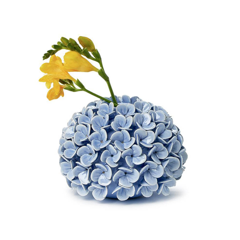 Two's Company Blue Hydrangea Porcelain Flower Bud Vase and Taper Holder, front view with yellow flowers.