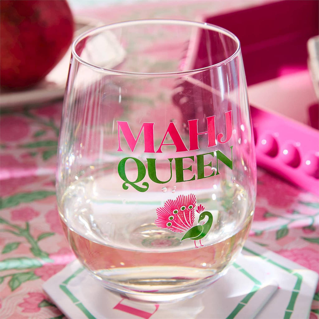 Clear glass with 'MAHJ QUEEN' text and logo on a colorful tablecloth.