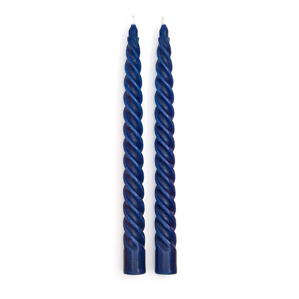 Two navy blue twisted taper candles on a white background.