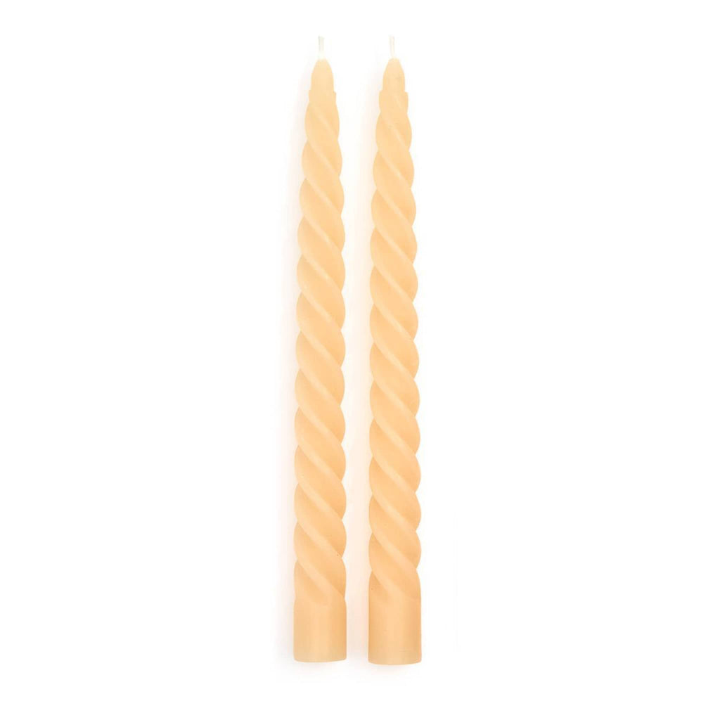 Two twisted ivory taper candles on a white background.