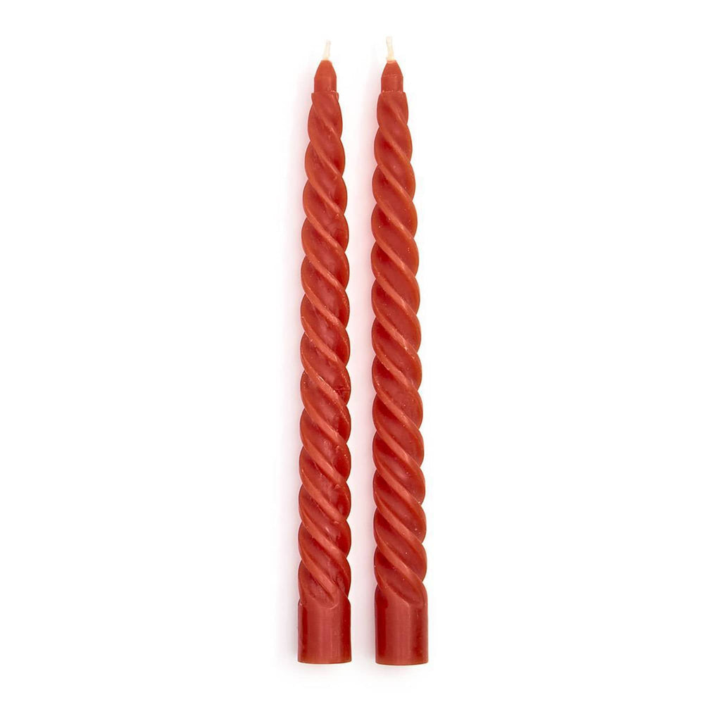 Two twisted rust red candles on a white background.