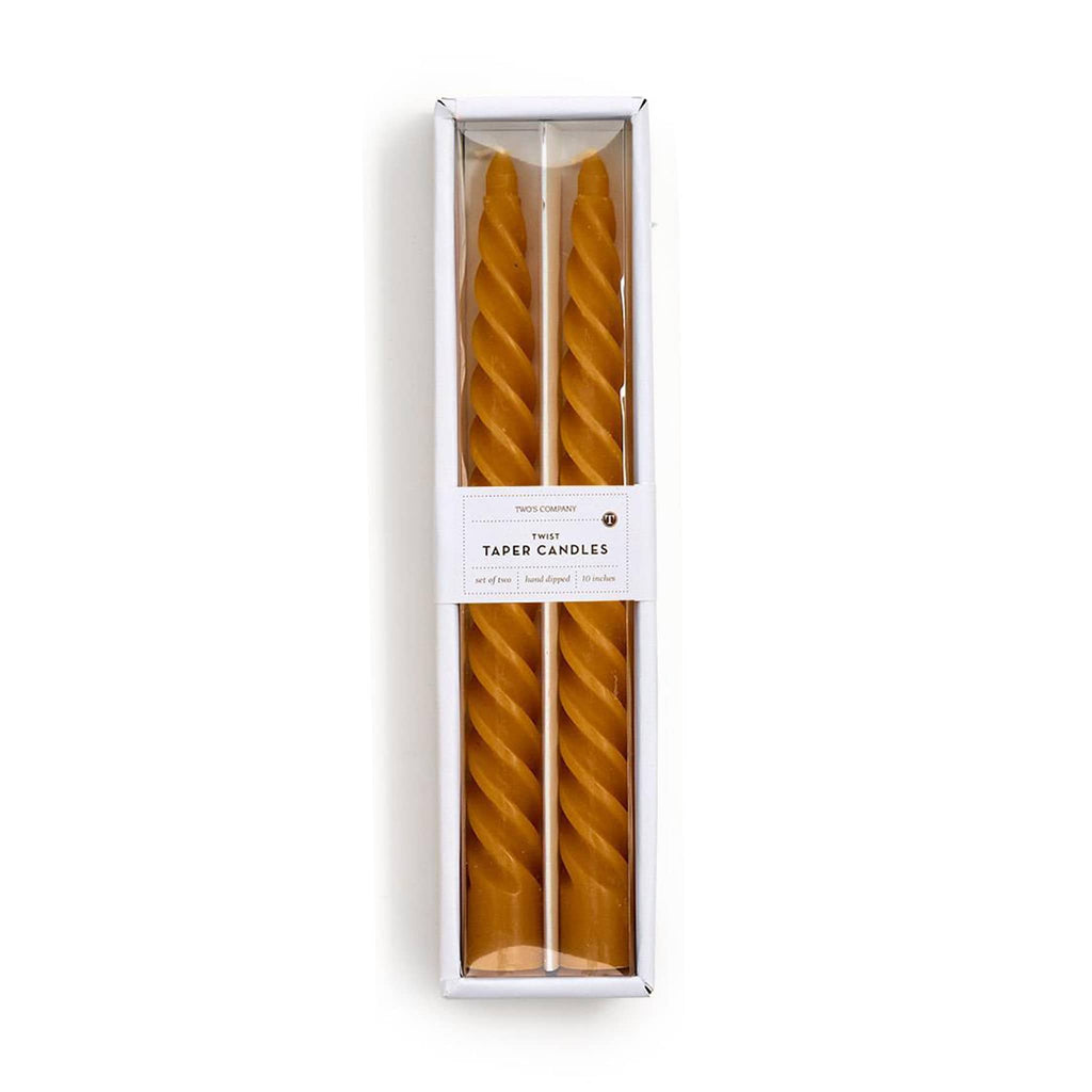 Two yellow twisted taper candles in a white box on a white background.
