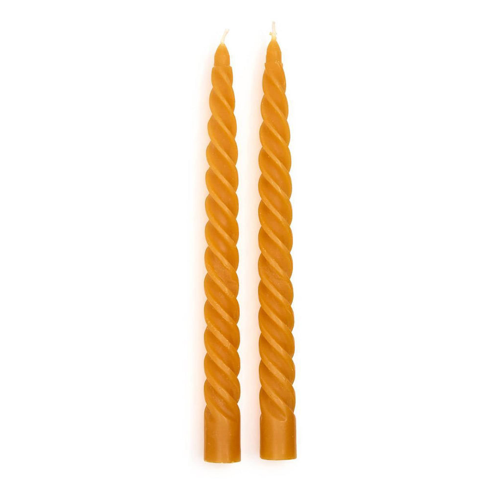 Two twisted yellow candles on a white background.