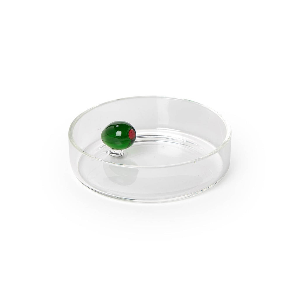 Clear glass tidbit or dipping dish with a green glass olive inside, on a white background.