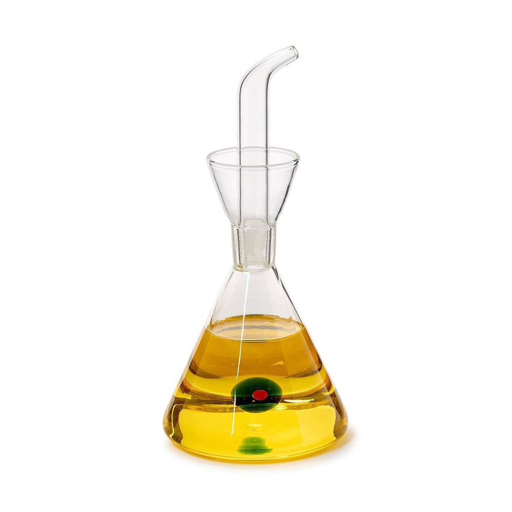 Clear glass oil dispensing carafe with a glass green olive inside, filled with olive oil, on a white background.
