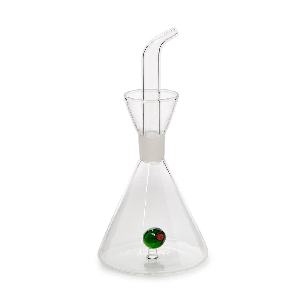 Clear glass oil dispensing carafe with a glass green olive inside, on a white background.