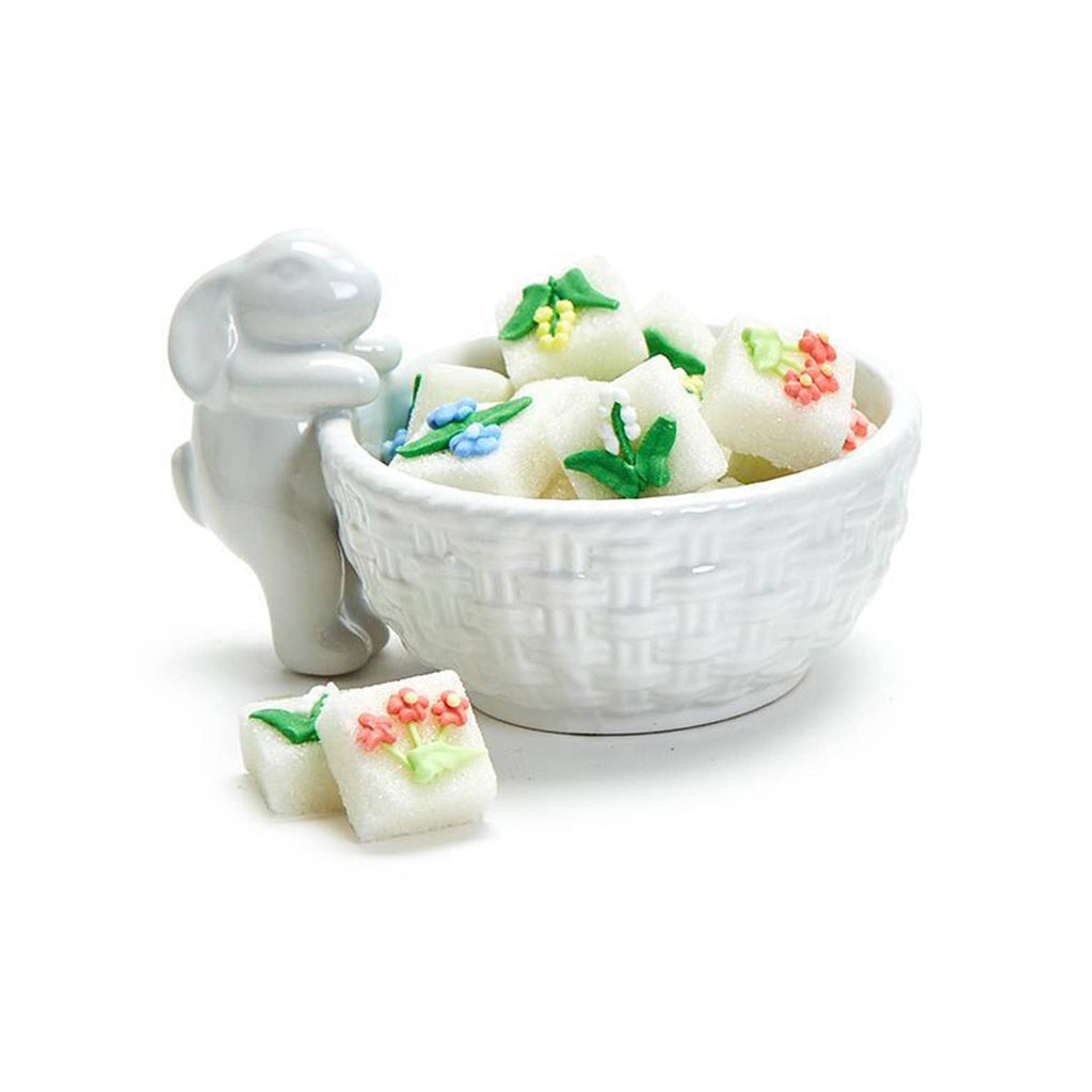 Two's Company Tiny Standing Bunny Easter white dolomite tidbit bowl with woven pattern and a little bunny standing with its front paws on the rim of the bowl filled with decorated sugar cubes.