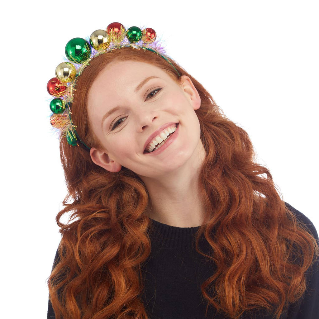 Two's Company Baubles Belle light up holiday headband with tinsel, lights on, on models head.