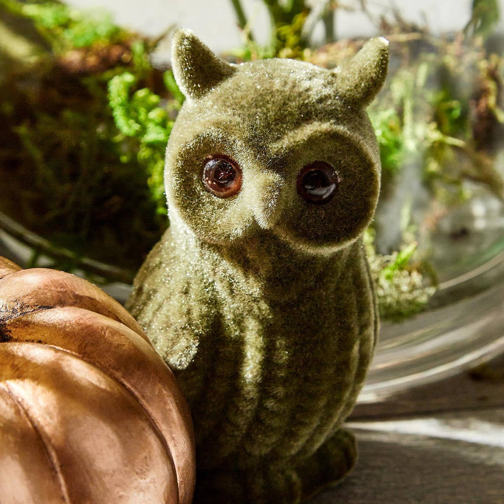 Green flocked owl figurine with a terrarium background.