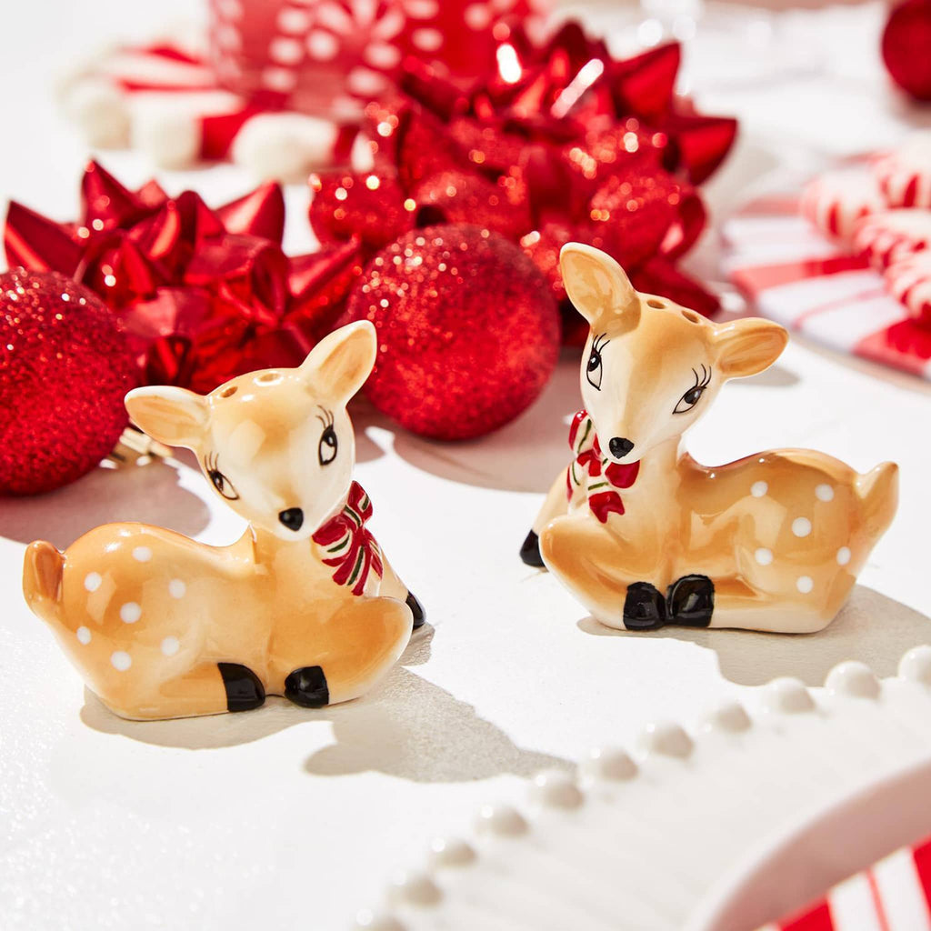 Two's Company hand-painted vintage deer salt and pepper shaker set on a holiday table with red ornaments and bows.