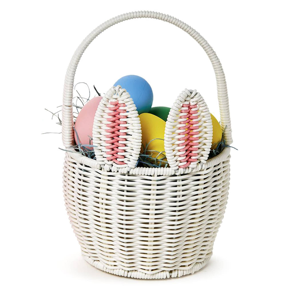 Two's Company White Faux Wicker Easter Basket with bunny ears, handle and pom pom tail, front view, filled with grass and colored eggs.