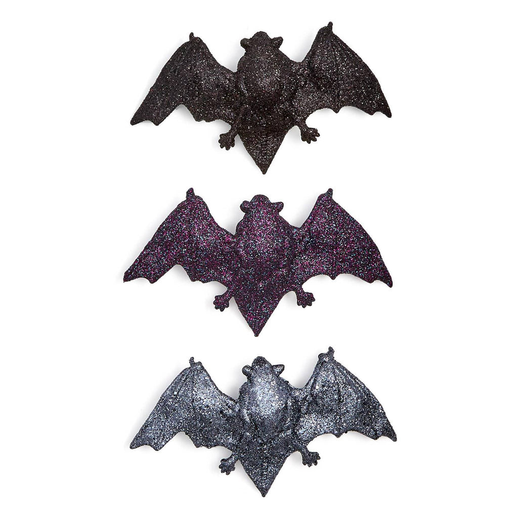 Three glittery bat decorations on a white background.