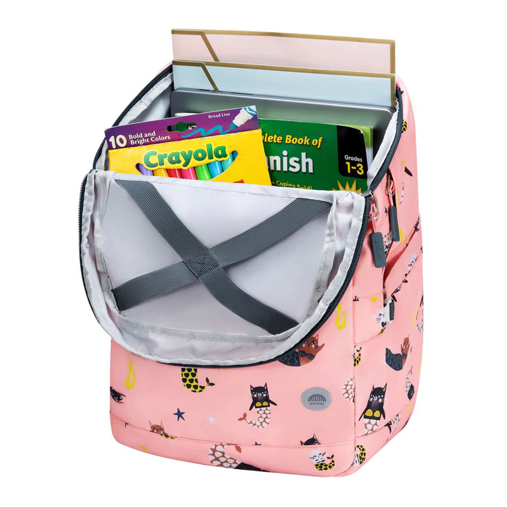 Uninni pink Swimming Mercats Bailey Backpack, top open showing school supplies inside.