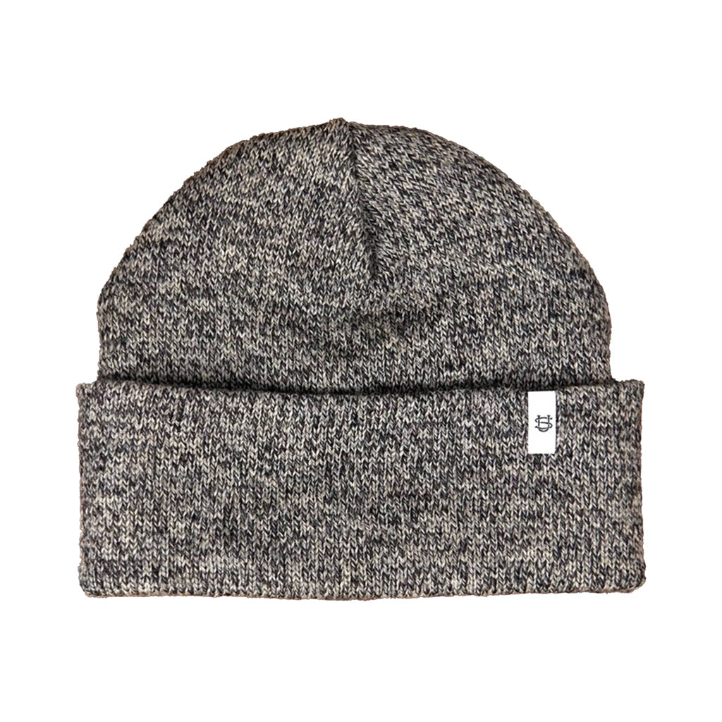 Charcoal gray and black wool knit beanie with a small white logo label on a white background.