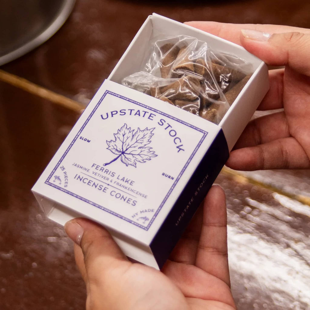 Box of Upstate Stock incense cones held by a person.