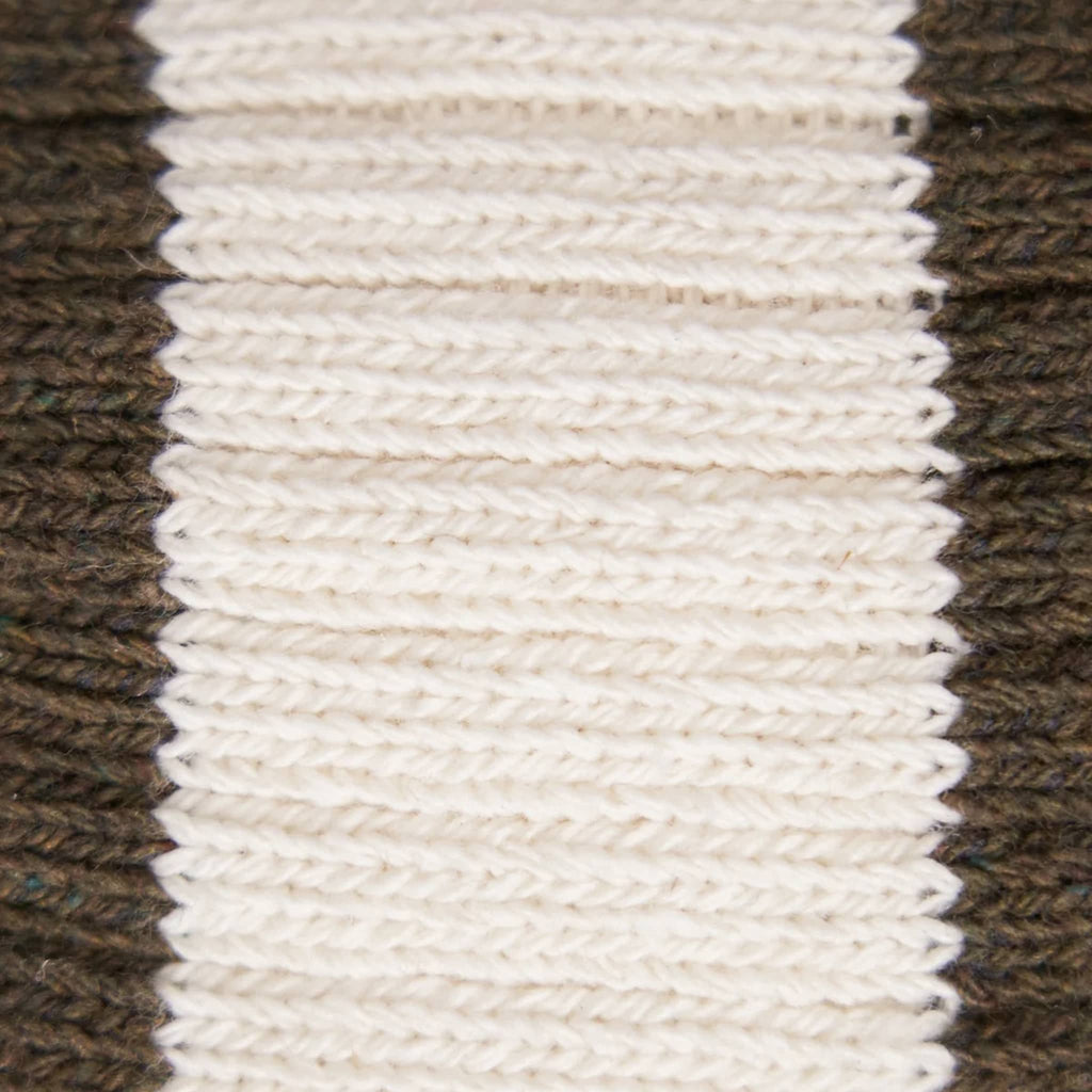 Close-up of a knitted fabric with olive and white stripes.