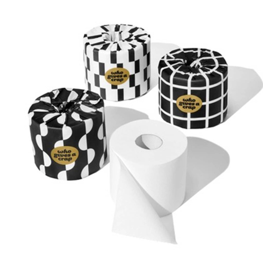 Who Gives a Crap Premium 100% Bamboo Toilet Paper Rolls wrapped in black and white paper with various designs and one unwrapped.