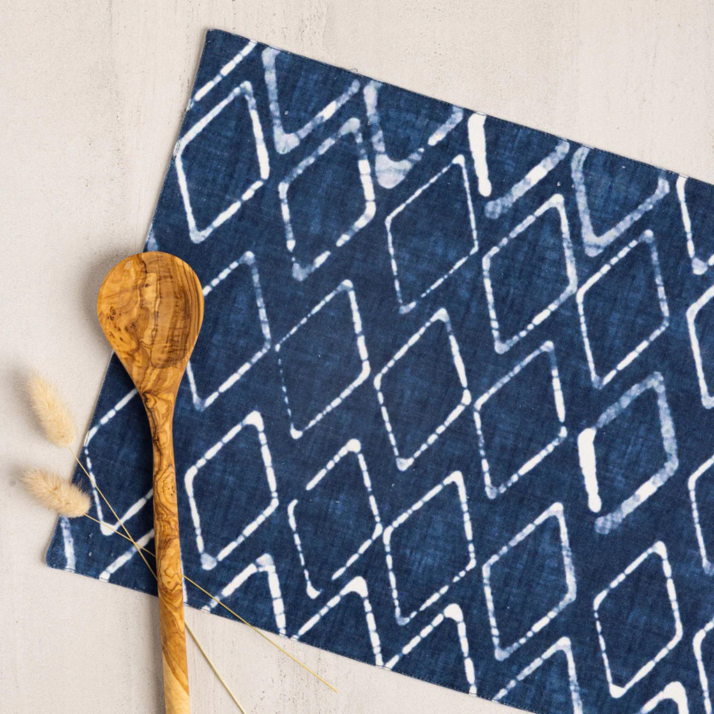Wolf & Irving organic cotton placemat with a navy blue and white batik pattern with a wooden spoon.