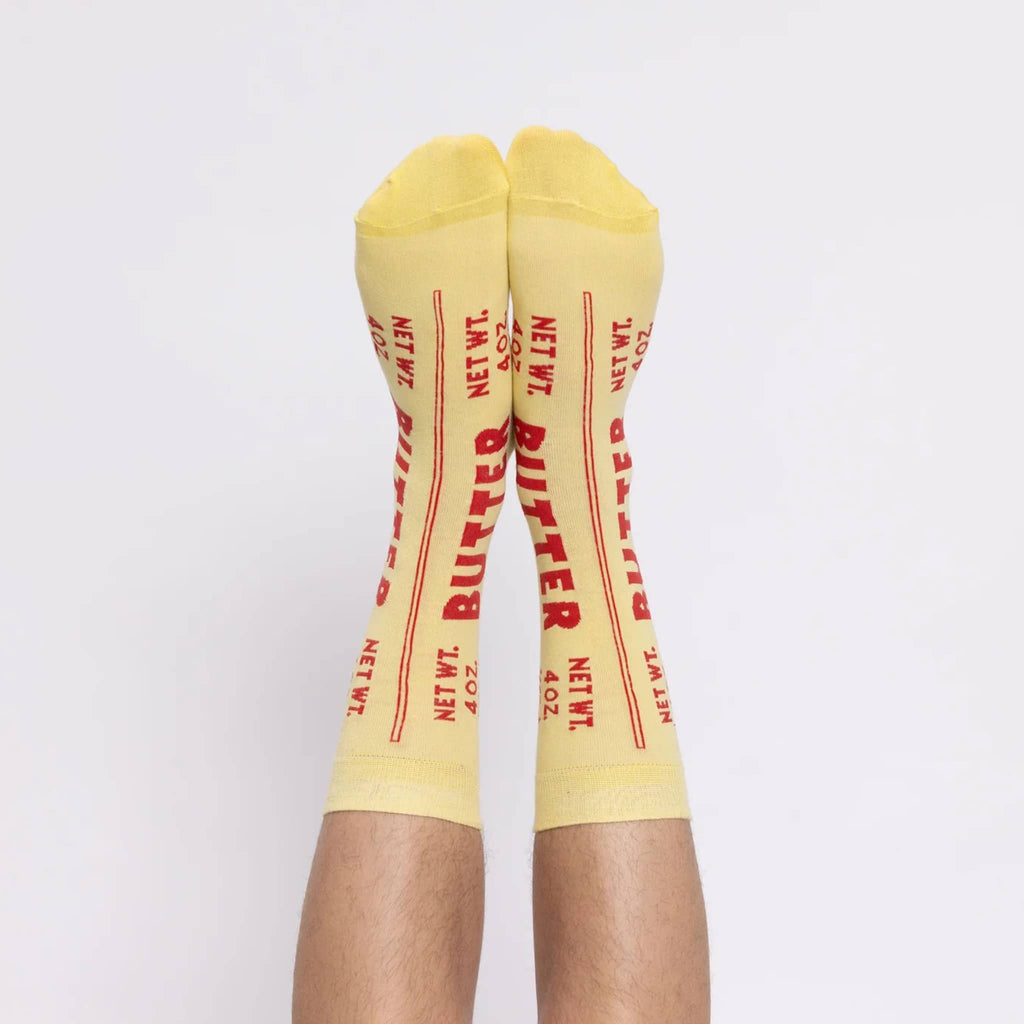 Yellow Owl Workshop large soft yellow crew socks that look like a stick of butter, on feet.