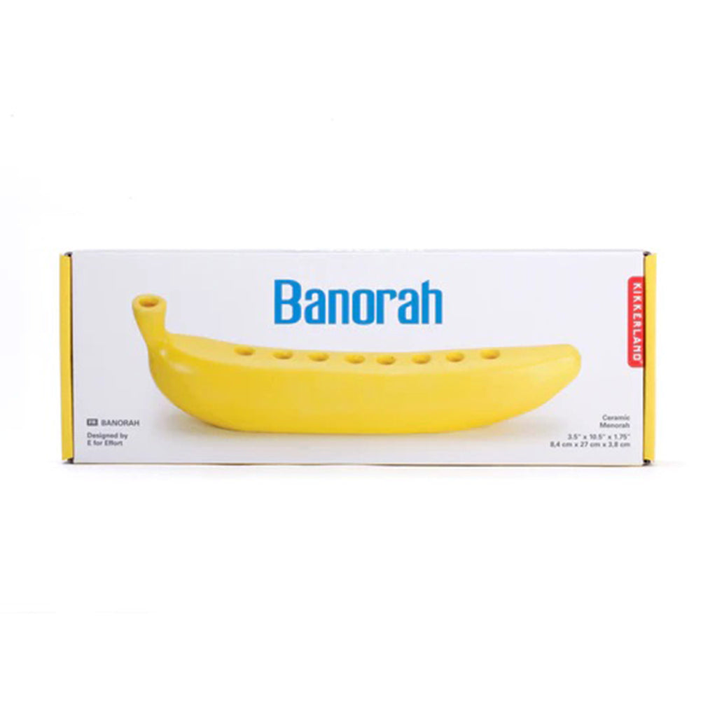 Kikkerland Banorah, yellow ceramic menorah in the shape of a banana, in box packaging, front view.