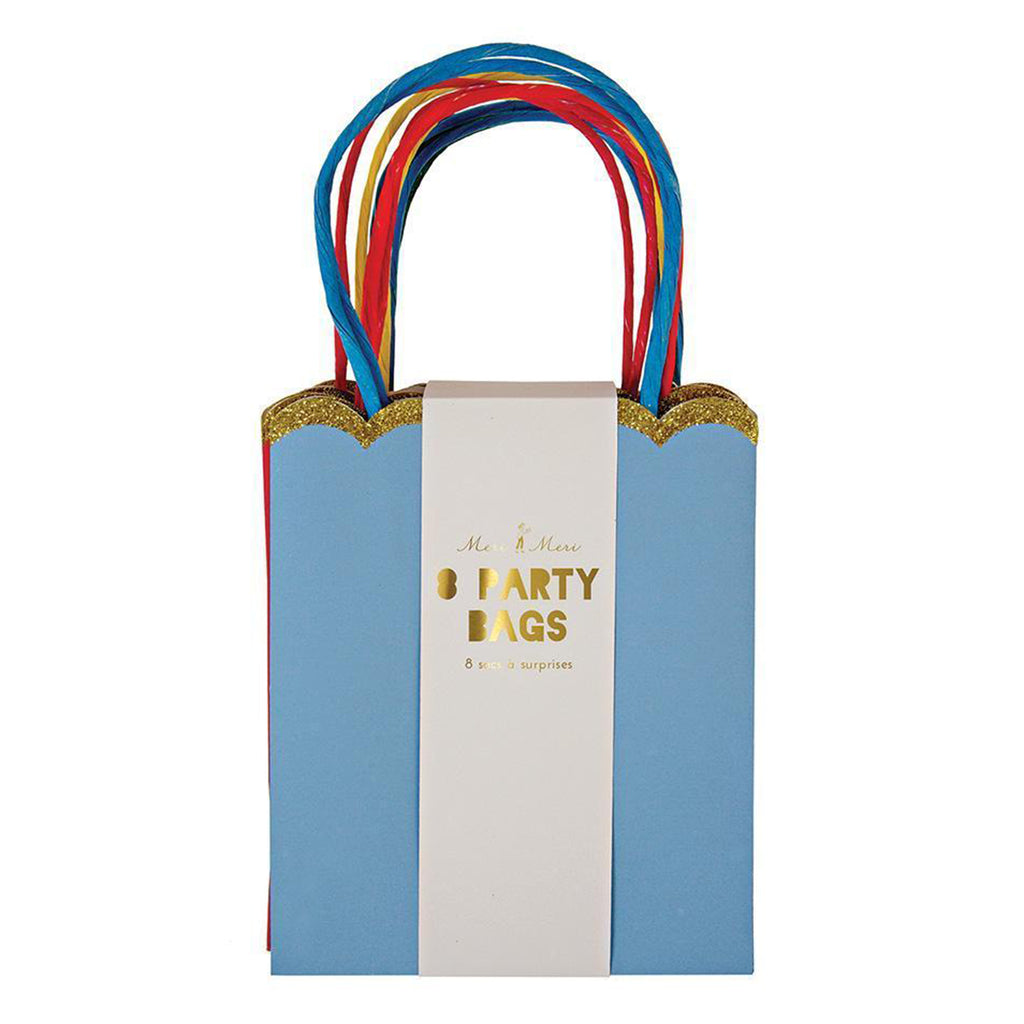 Pack of 8 party bags in solid rainbow colors, top edge is scalloped and has a gold glitter trim, raffia handles match the bag colors. Packaged by a white belly band that says "meri meri, 8 party bags" in gold foil lettering.