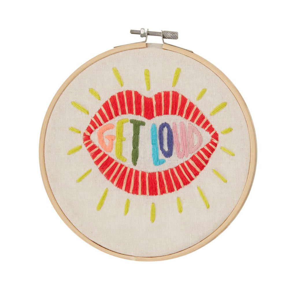 Accent Decor "Get Loud" Embroidery Kit finished in wooden embroidery hoop. Red lips with "get loud" in colorful letters in the mouth, stitched on off-white fabric.