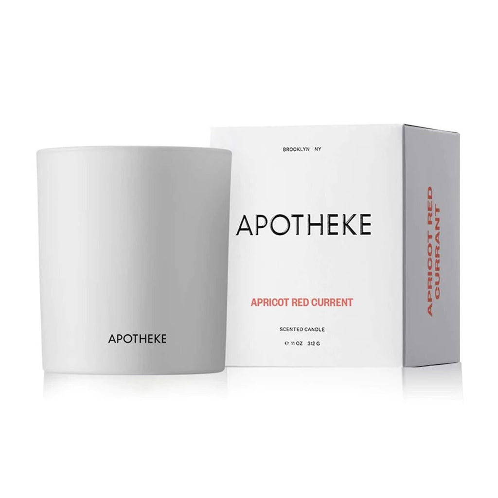 Apricot Red Currant scented candle from Apotheke in matte white glass vessel with white gift box that has black and orange lettering.