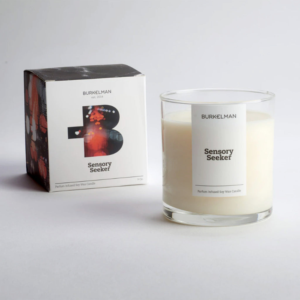 burkelman sensory seeker scented soy wax candle in clear glass tumbler with white label and box with white front with cutout B and red city lights in it