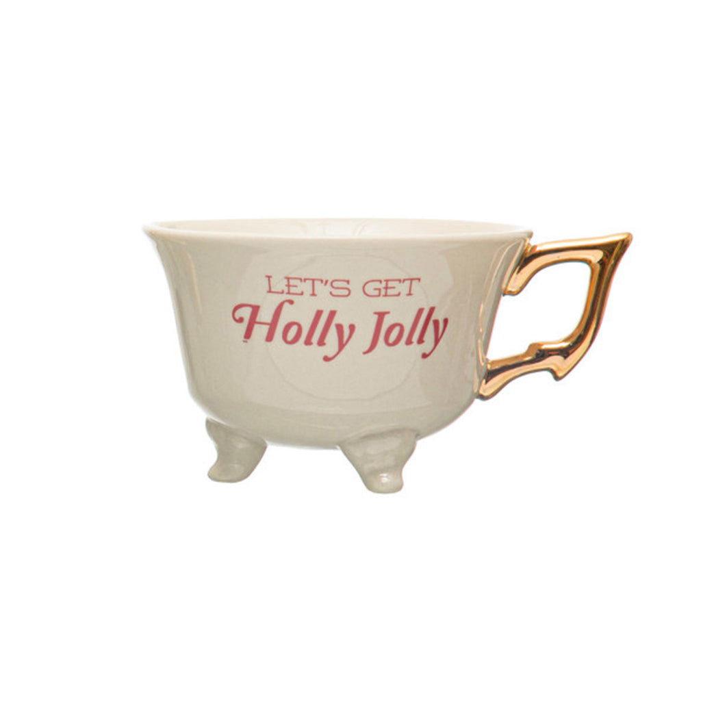 Creative Co-op stoneware footed teacup with "let's get holly jolly" in playful red lettering and gold electroplated handle on the right.