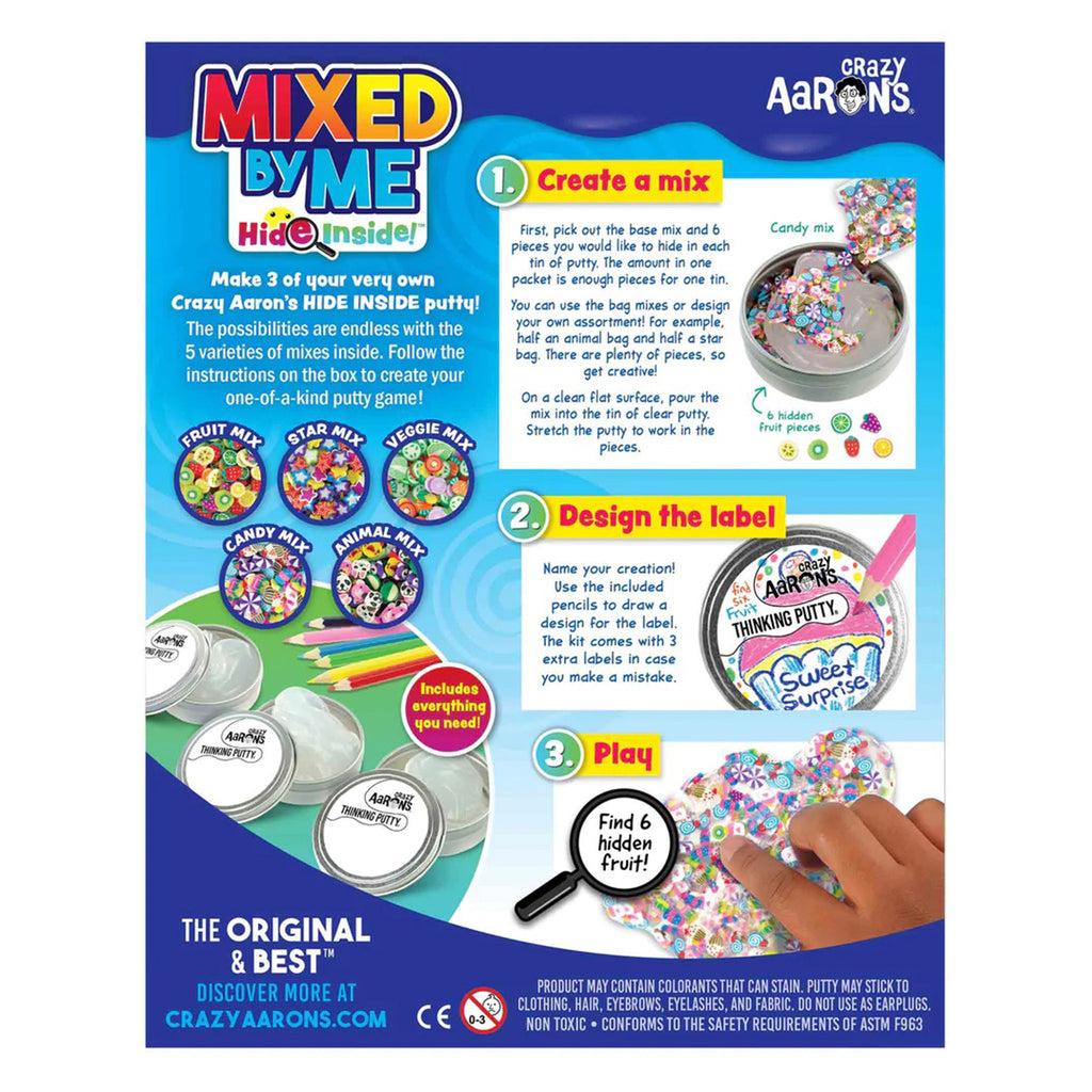 back of box with "mixed" in red to yellow ombre, "by me" in blue and "hide inside" in red, pink, blue and green. On right side, written instructions for creating your own putty along with pictures and on left side shows contents including the 5 varieties of clay pieces to mix in.