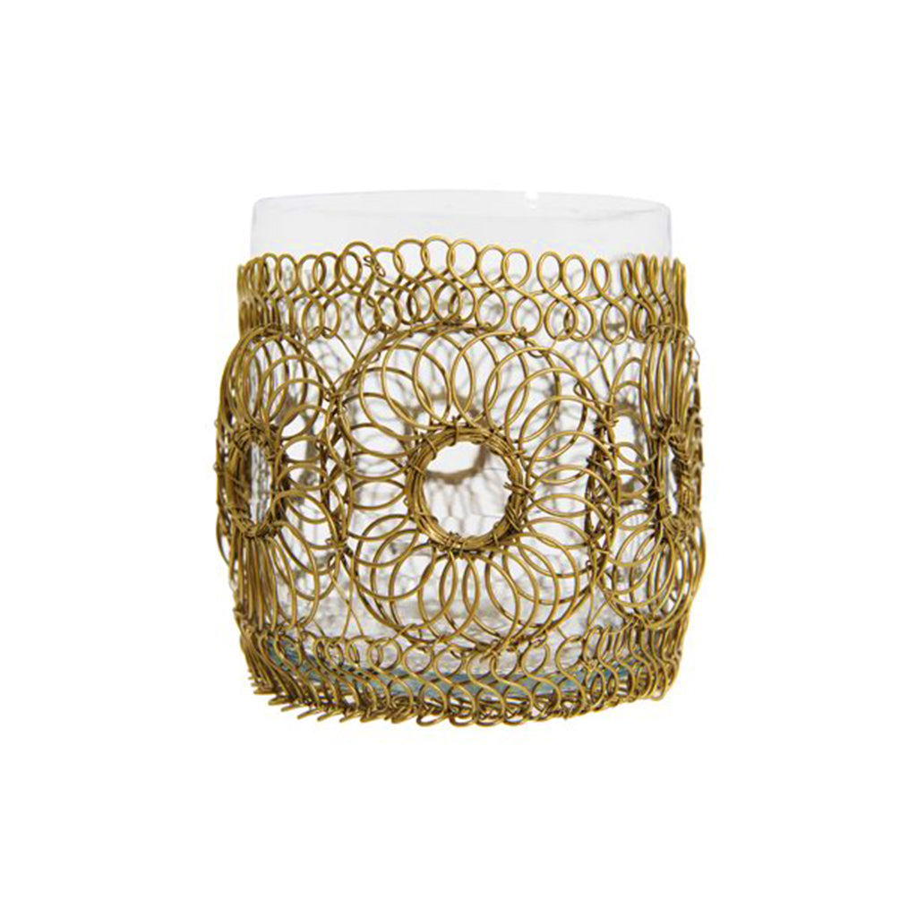 Votive holder with circles of brass finish woven wire and a clear glass insert, front view.