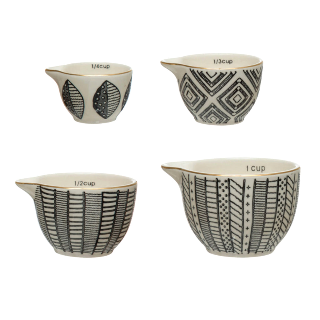 creative co-op set of four nesting hand painted stoneware measuring cups with different black and white patterns and gold rim