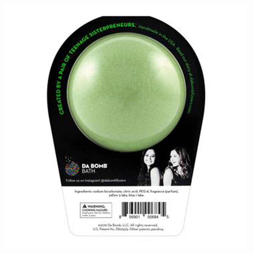 Da Bomb Glow Bomb, glow-in-the-dark green bath fizzer with honeydew scent and a light-up surprise inside, in black clamshell packaging, back view.