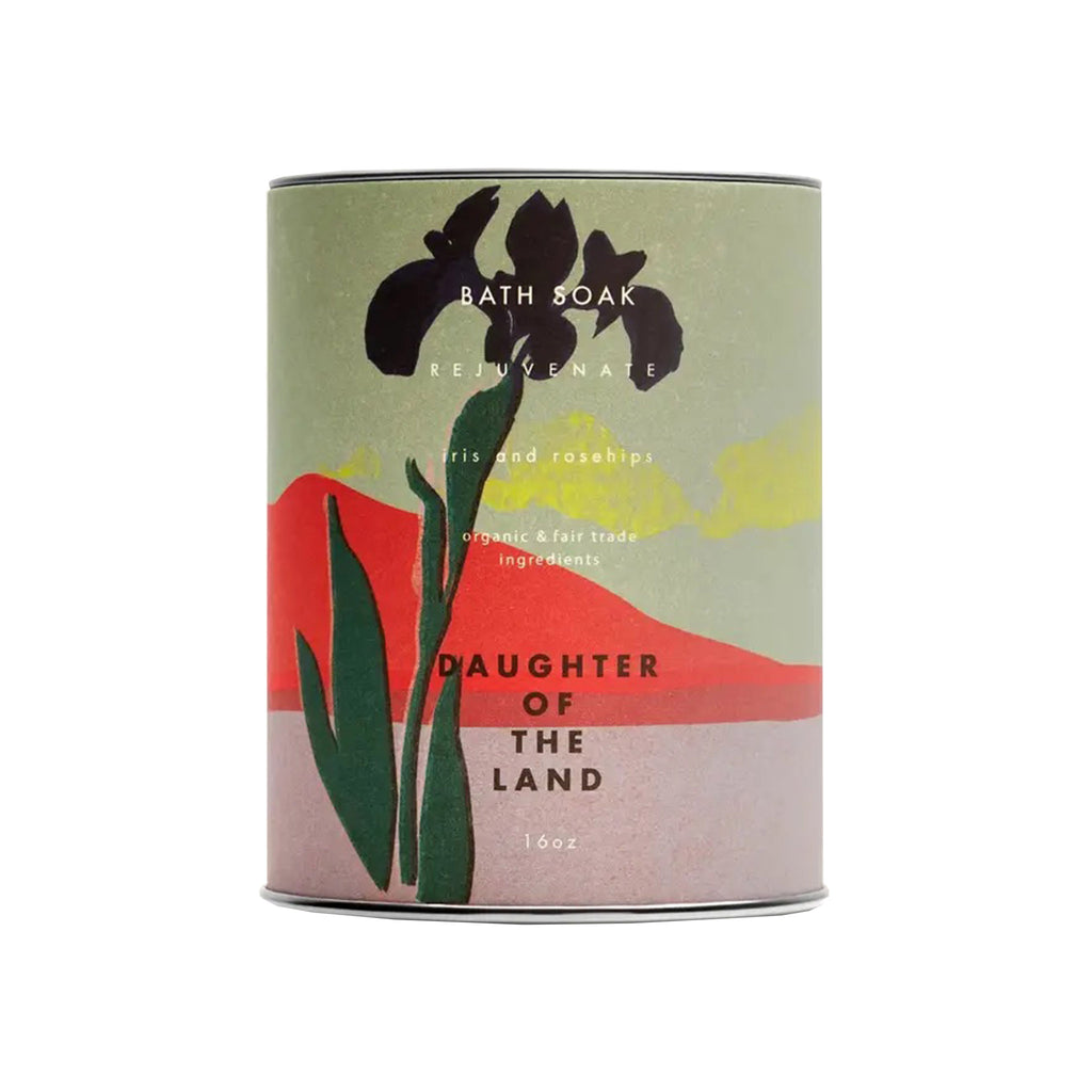 Daughter of the Land Rejuvenate Iris and Rosehips Bath Soak in 16 oz canister with an illustration of an iris against a red mountain with yellow clouds and a green sky.