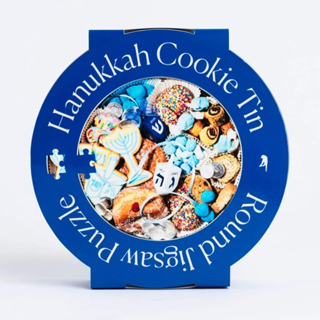 Piecework Puzzles 750 Piece Hanukkah Cookie Tin Round Jigsaw Puzzle in tin packaging with blue sleeve that has the puzzle image on it.