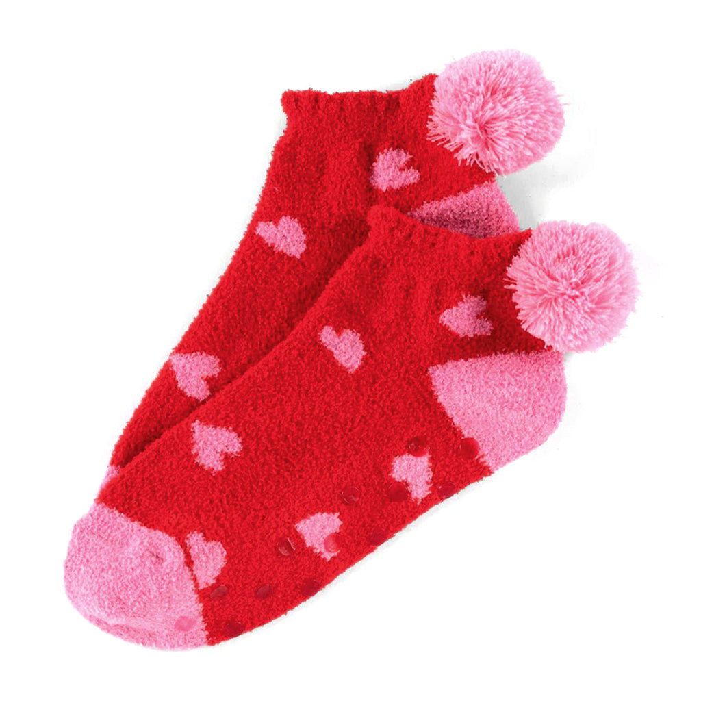 Shiraleah Hearts Home Socks, red plush socks with pink toe, heel and pompom at the ankle with pink heart pattern and rubber grip dots on the bottom.