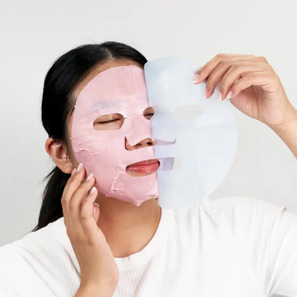 Facetory I Pinky Promise Rejuvenating pink sheet face mask treatment being applied on a woman.