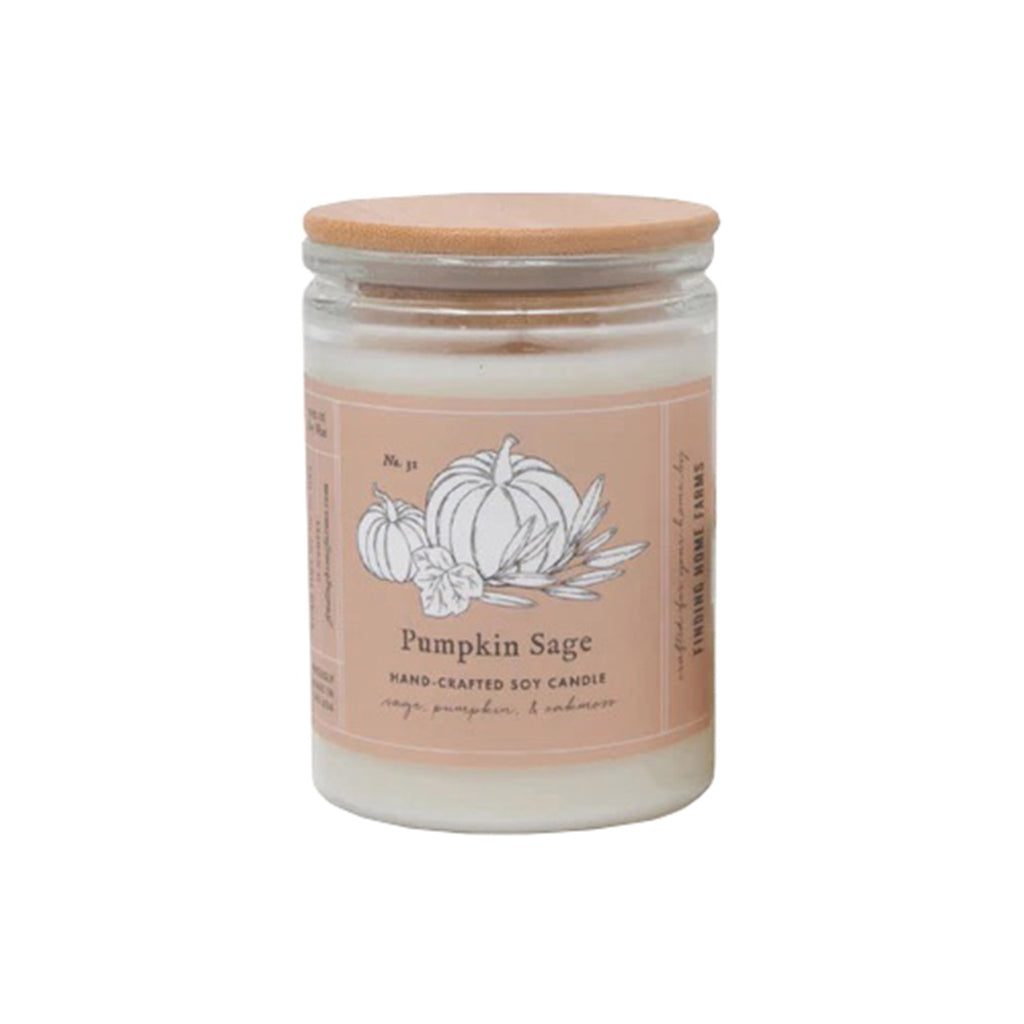 Large pumpkin sage scented candle in clear glass vessel with peach band that has a pumpkin illustration on it with a bamboo lid on top.
