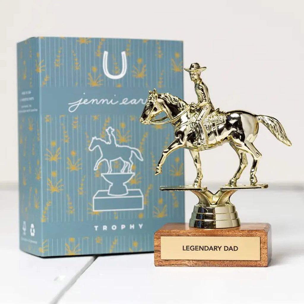 A horseback riding trophy mounted on a wood base with a plaque that says "legendary dad" next to a blue illustrated gift box.