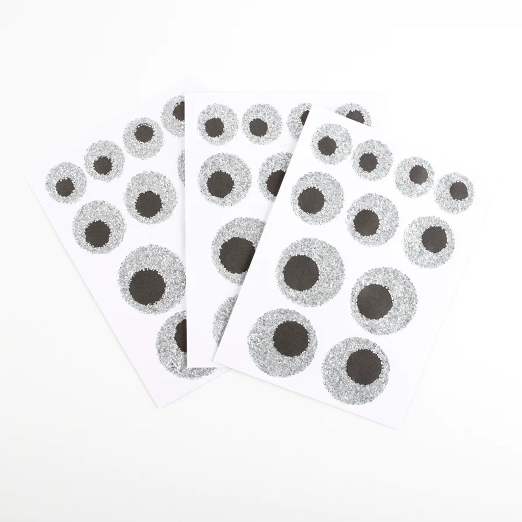 3 sheets of eyeball stickers with silver eco-friendly glitter and black pupils in varying sizes.