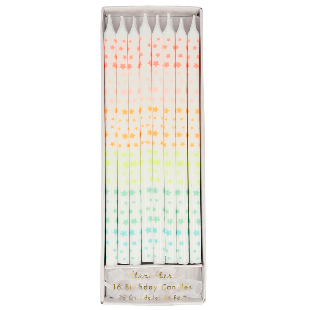 meri meri white birthday candles with small stars in neon pink, pale pink, orange, neon yellow, mint green and pastel blue in paper packaging with clear plastic lid and clear plastic candle holders