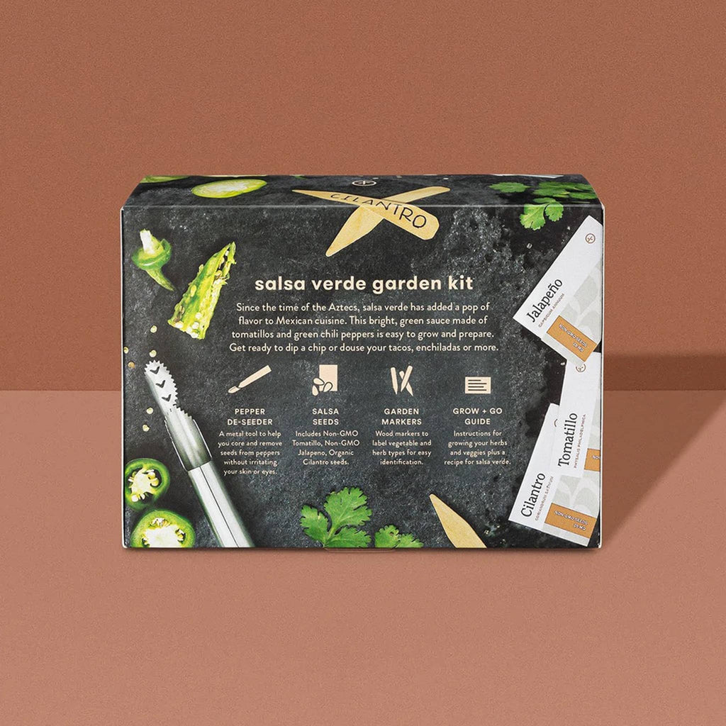 Back of black box packaging with a photo of green tomatillos, jalapenos and cilantro along with a stainless steel pepper deseeder, wooden garden markers and seed packets on a brown background.
