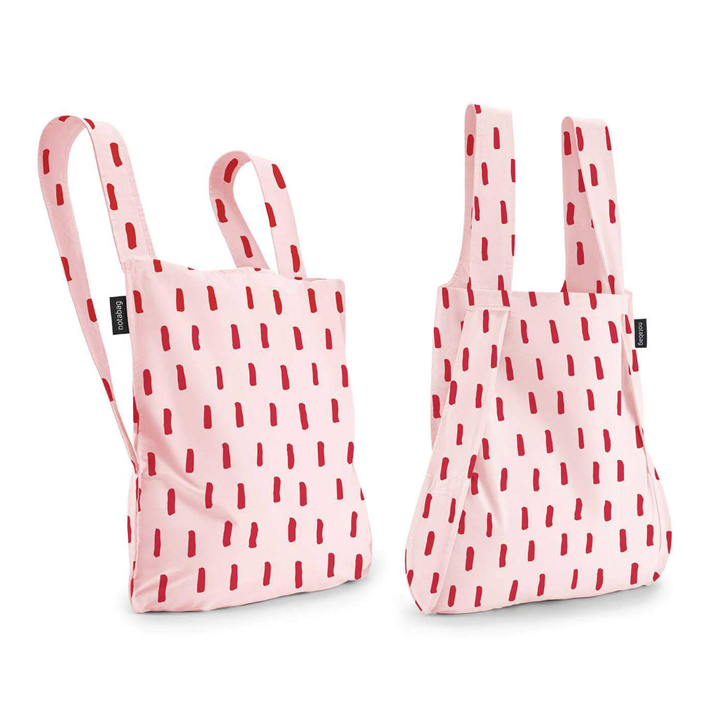 notabag reusable cotton and nylon bag that transforms from backpack to tote bag in red brush pattern with red lines on a pink backdrop